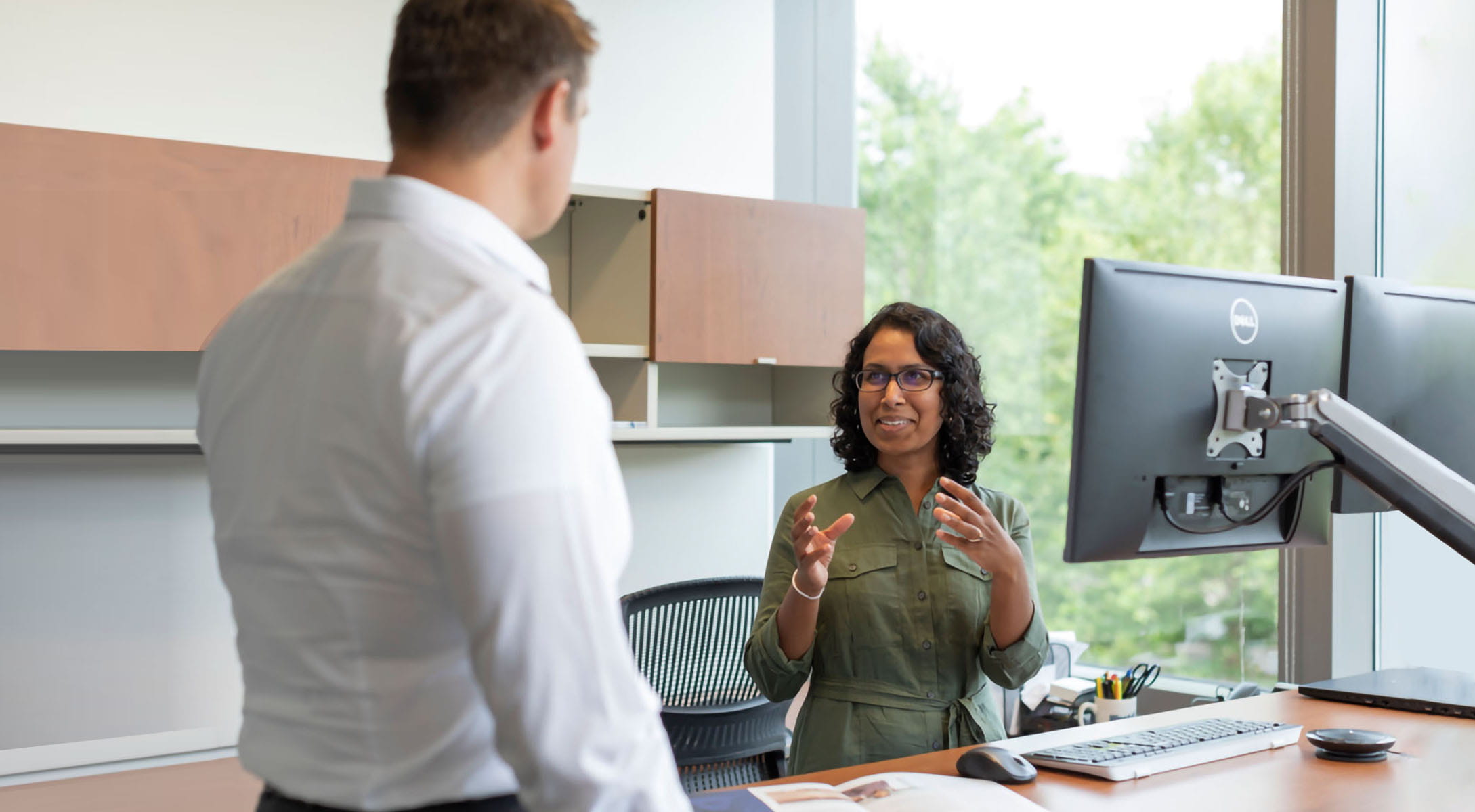 Two employees having a conversation in office setting