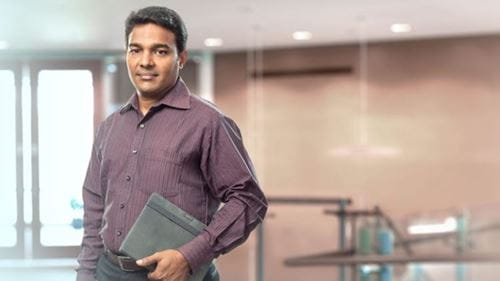 Team member holding notebook smiling at the camera