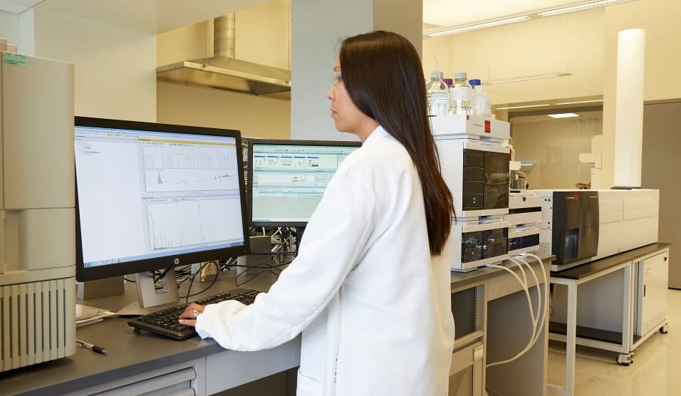 Scientist in a laboratory analyzing data on a computer for Leachables method validation