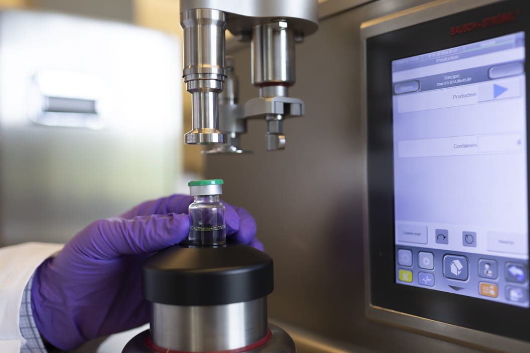 West technician performing container closure integrity testing on a sterile vial using advanced laboratory equipment.