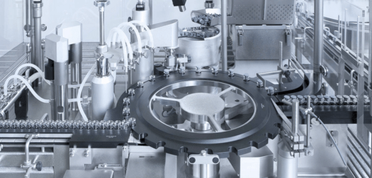 Aseptic pharmaceutical fill-finish machine processing glass vials on an automated production line.