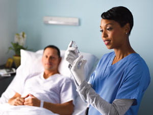 A nurse with a syringe and vial