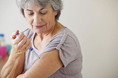 A patient with diabetes injecting themselves using a auto-injector