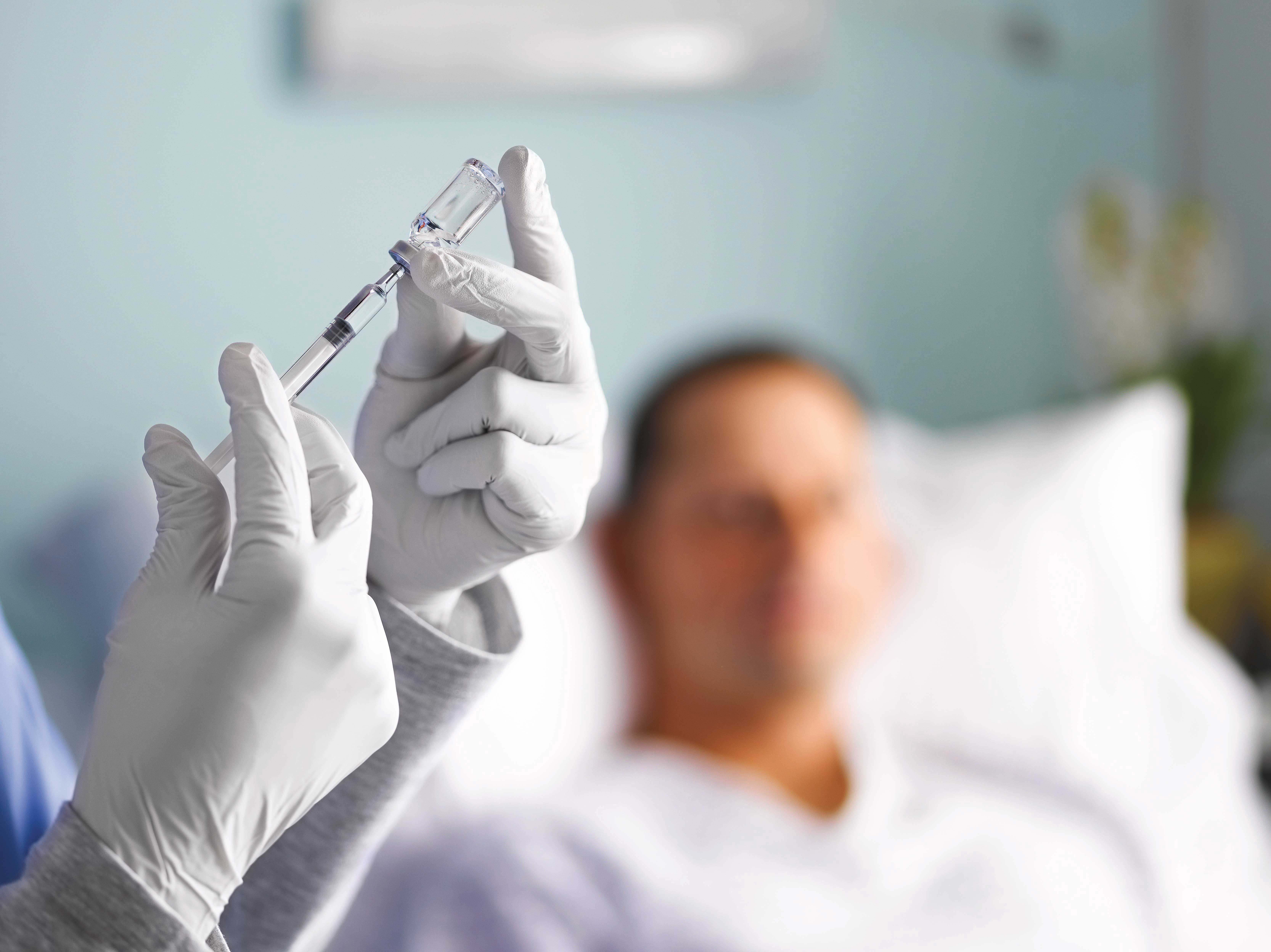 Syringe in use with nurse and patient